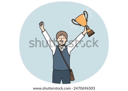 Schoolboy with golden cup rejoices at award received for winning school mathematics olympiad. Schoolboy with trophy makes winning gesture demonstrating leadership qualities while receiving education