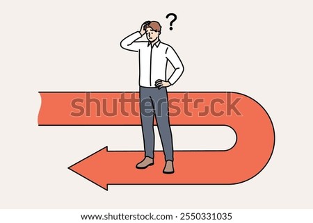 Frustrated businessman has fallen victim to crisis and is forced to move backwards to avoid bankruptcy, scratching head. Sad manager stands on red arrow back symbolizing recession and crisis