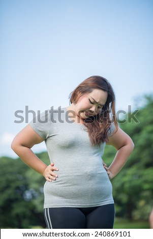beautiful fat woman check her paunch in the garden