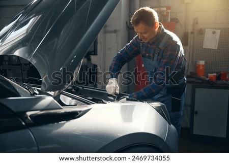 Similar – Image, Stock Photo Busy male mechanic repairing motorcycle seat in workshop