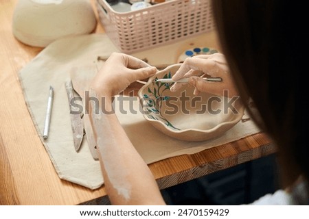 Image, Stock Photo Craftswoman painting a bowl made of clay in art studio