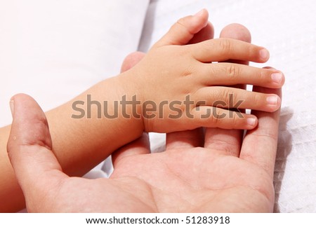 Baby taking his father hand. white background