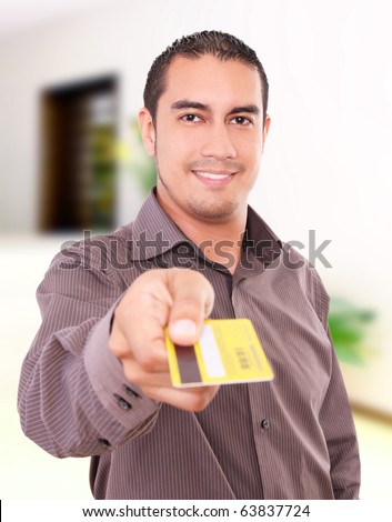 Young man smiling and giving his credit card