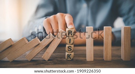 close-up hand The hand of a businessman who is stopping or preventing a falling block.Risk protection concept,Eliminating the risk
