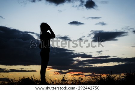 The silhouette of a girl with a sad thought to want peace in the evening before sunset.