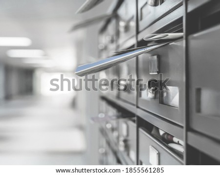 Mailboxes in the condominium. Mailboxes filled. Mail boxes filled of leaflets and letters. Defocused blurry background.