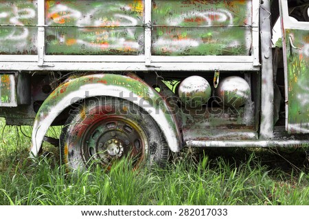 An old abandoned pickup truck, painted with bright colors.