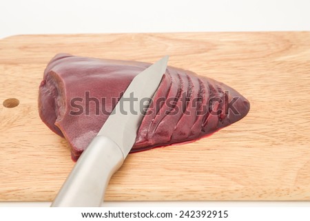 Close up of fresh and raw pig\'s liver with knife slice in pieces for healthy diet and local food preparation background