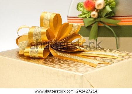 Close up of golden gift box and fresh baked cookies in silver box with bow and colorful wrapping for giving to someone special on any event