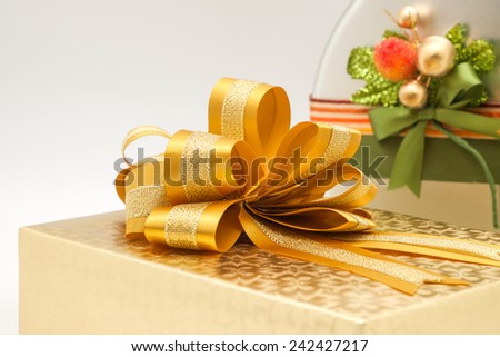 Close up of golden gift box and fresh baked cookies in silver box with bow and colorful wrapping for giving to someone special on any event