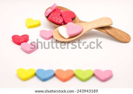 Close up of colorful hearts on wooden spoon as symbol of love, valentines and happiness for special occasion