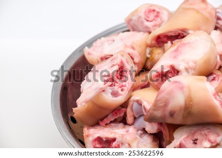 Close up of fresh raw pig\'s feet and pork meat on white background