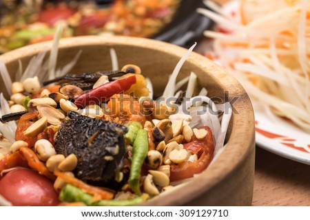 Fresh hot and spicy green papaya salad for tradition thai food appetizer in wooden bowl