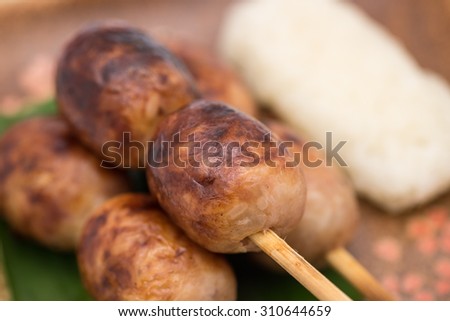 Top view of Thai pork sausage with sticky rice on ceramic plate for local food background