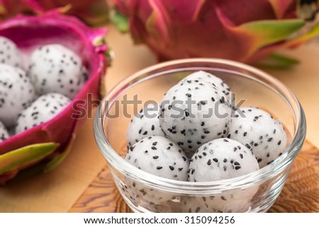 Sweet tropical dragon fruit crafted in balls in ceramic glass bowl on wood table for dessert serving