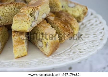 Cantucci, a tipical tuscan biscuits on a white cake stand.