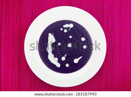 Violet potato and leek soup with cream.
