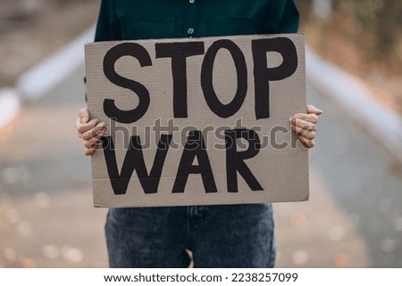 Image, Stock Photo Peace demonstration against the war of aggression against Ukraine started by Putin. Demonstrator in the national colors of Ukraine holding up a sign. Rear view