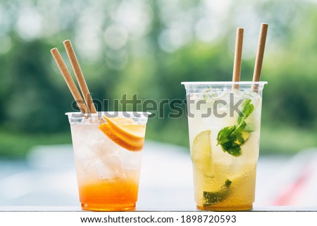 Cold ice beverage alcohol drink with fruits. Drikk with lemon,orange and ice. Water background. Foto d'archivio © 