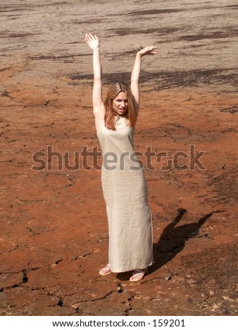 Girl in long dress standing and holding hands above her head