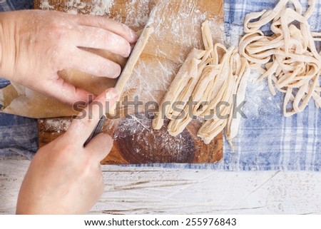 Fresh Homemade Pasta Dough Recipe on Table Filled with Flour and Wooden Roller on Side. Handmade ribbon pasta. Homemade pasta concept . Step on step recipe. See series. Rustic style