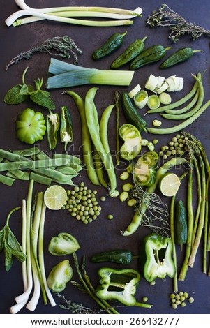 Collection of fresh green vegetables on blue metal table, asparagus, leek, string beans, french beans, fresh peas, lettuce, tomatoes, peppers, onions, lime. Organic and healthy vegetables.