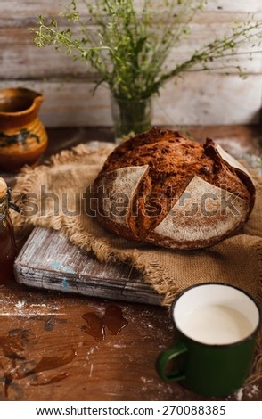 Homemade whole bread with pottery pitcher of milk. Natural local food. Rustic style.