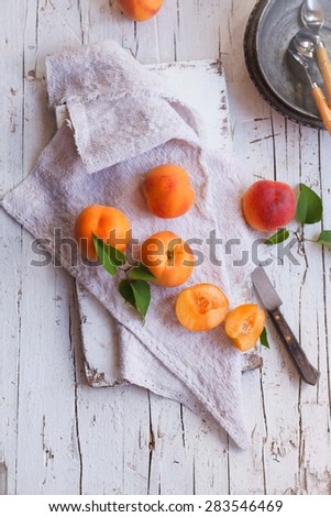Ripe yellow peach over a rustic linen cloth  with knife and vintage plates. Rustic style.