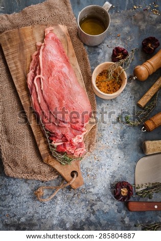 The best raw steaks meat served on vintage cutting board ready to cook, from above. Rustic style.