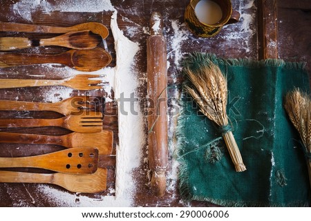 Composition of traditional rustic kitchen utensils with rolling pin and rustic embroidery cloth situated from above vintage kitchen wooden table. Country, homemade and real food concept. Rustic style.