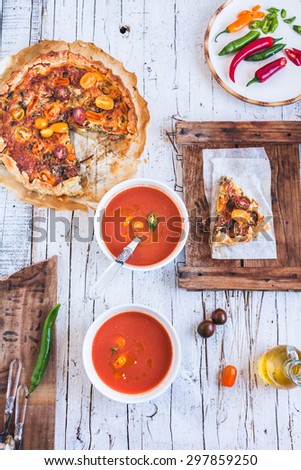 Spanish traditional tomato soup Gazpacho with ricotta tart from above on a rustic kitchen styling table.