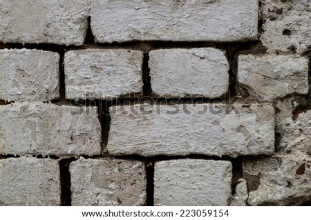 white painted brick wall with a big gaps between bricks