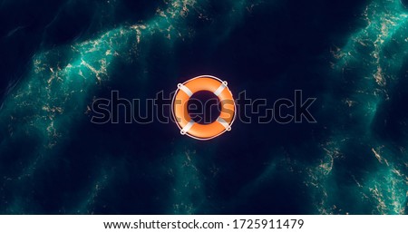 Life buoy. Life buoy in water. Top view of lifebuoy. Life ring floating in a sea. Life preserver in sea. Top view of rescue ring. Rescue ring. Safety ring.