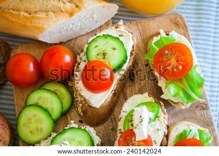 Small bites for breakfast with vegetables and cheese, on wooden table, top view and closeup