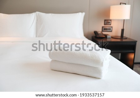 Clean white bath towels on the neatly clean bed of hotel room - coziness and clean concept	