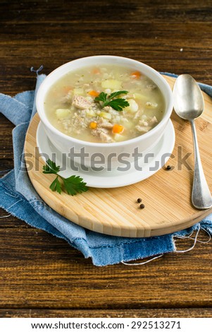 Polish Pearl Barley Soup on a brown wooden table
