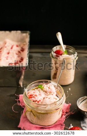 ice cream with strawberries and meringue served in a jar