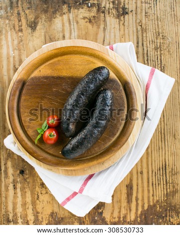 Black pudding on a cutting board on a rustic, wooden table