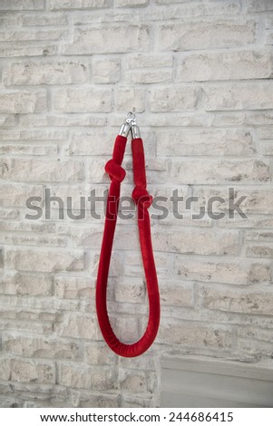 red rope cloth cover chain inside hanging on white stone wall