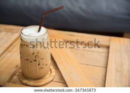 fresh iced coffee and delicious chocolate crape cake serve on wooden tray in coffee shop