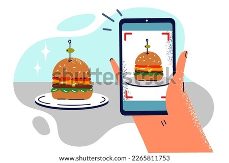 Hand with phone taking photo of hamburger on plate to share snapshot of lunch on social networks. Shooting hamburger on smartphone for online advertising or adding illustration to menu
