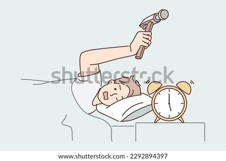 Annoyed man hits alarm clock with hammer not wanting to wake up on day off and go to unloved job. Sleeping guy lying in bed under covers wants to break alarm clock with annoying call 