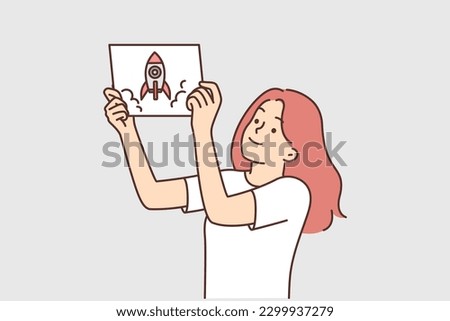 Girl demonstrates drawing of spaceship or rocket taking off and dreams of becoming woman astronaut. Schoolgirl shows picture of spaceship symbolizing growth and development in education or career