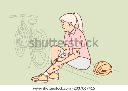 Woman cyclist has injured leg after falling off bike and sits on curb in need of doctor help. Concept of accident during bike ride due to careless riding and violations of safety rules