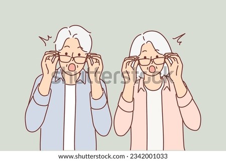 Elderly surprised couple takes off glasses and looks at screen after learning about big promotions and sales for shopping. Surprised grandparents shout wow and feel excited about unexpected news