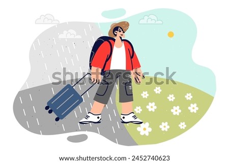 Man travels and sees climate change after trip to south during vacation, standing with tourist suitcase. Smiling guy changes climate zone by moving from rainy area to sunny region.