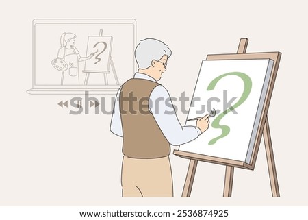 Elderly man artist draws picture using advice from video lesson on laptop, developing own creative potential. Grandfather uses easel and brush after retirement, draws abstract composition