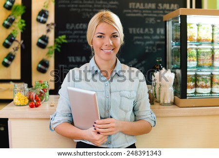 The owner of small restaurant holding a digital tablet