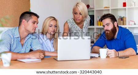 Team of young casual dressed people working in office.