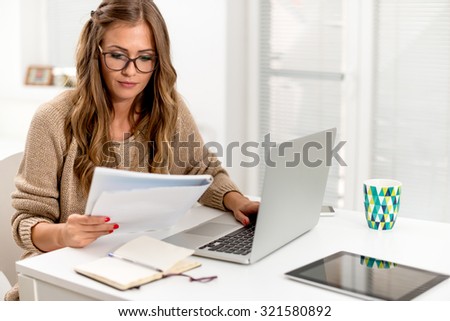Attractive young woman surfing the net from her home